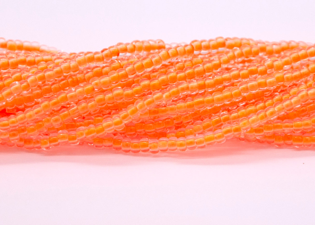 8SB734-N: CZ Seed Bead Neon Lined Orange 8/0 UV Reactive 6HK